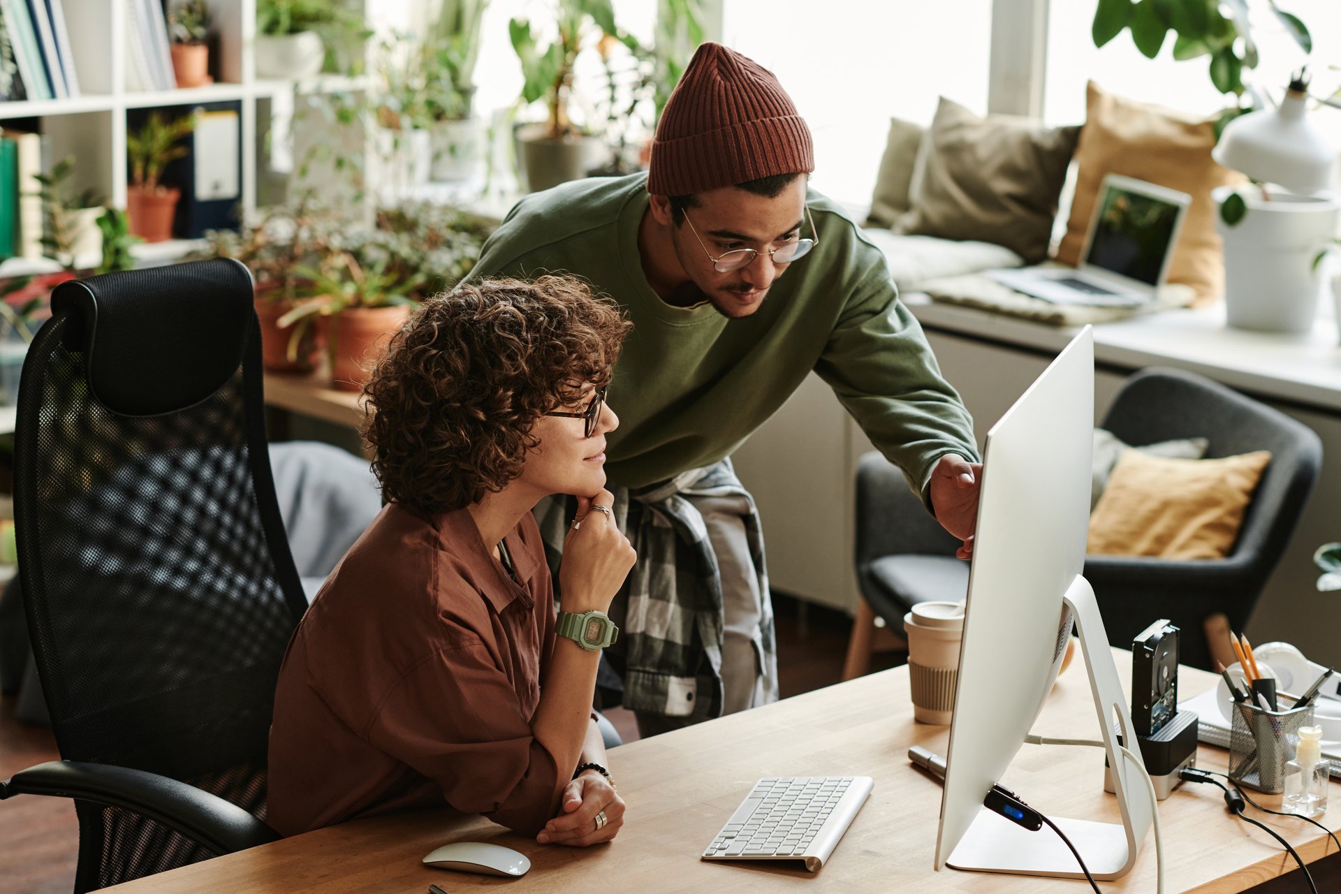 Colleagues helping each other at a desktop computer