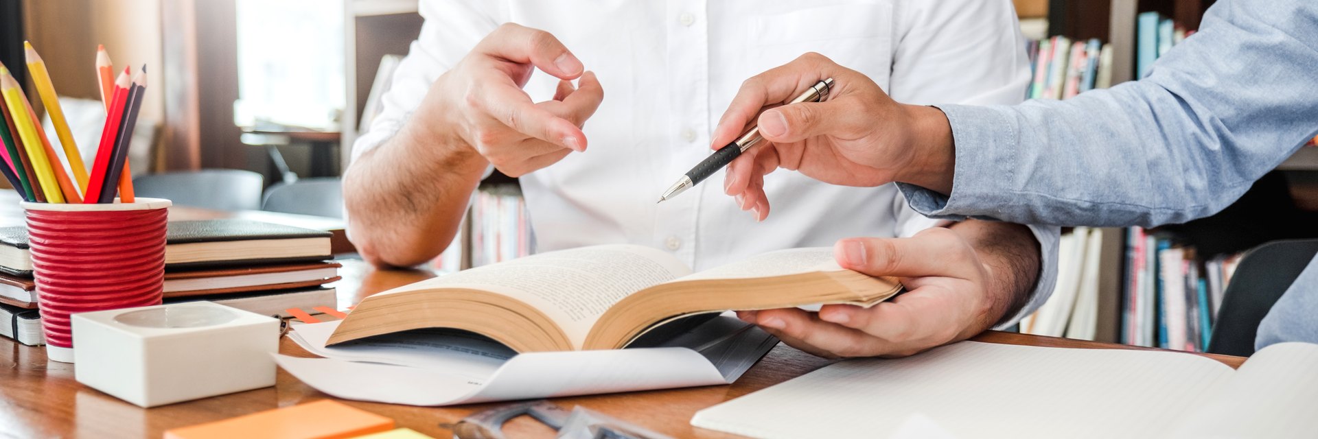 People discussing an open book and taking notes
