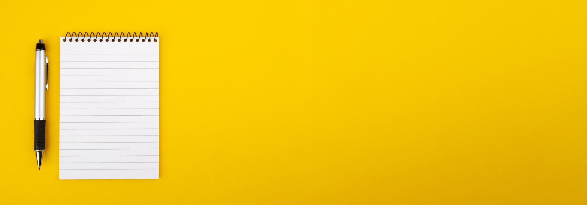 Notebook and pen on a yellow background