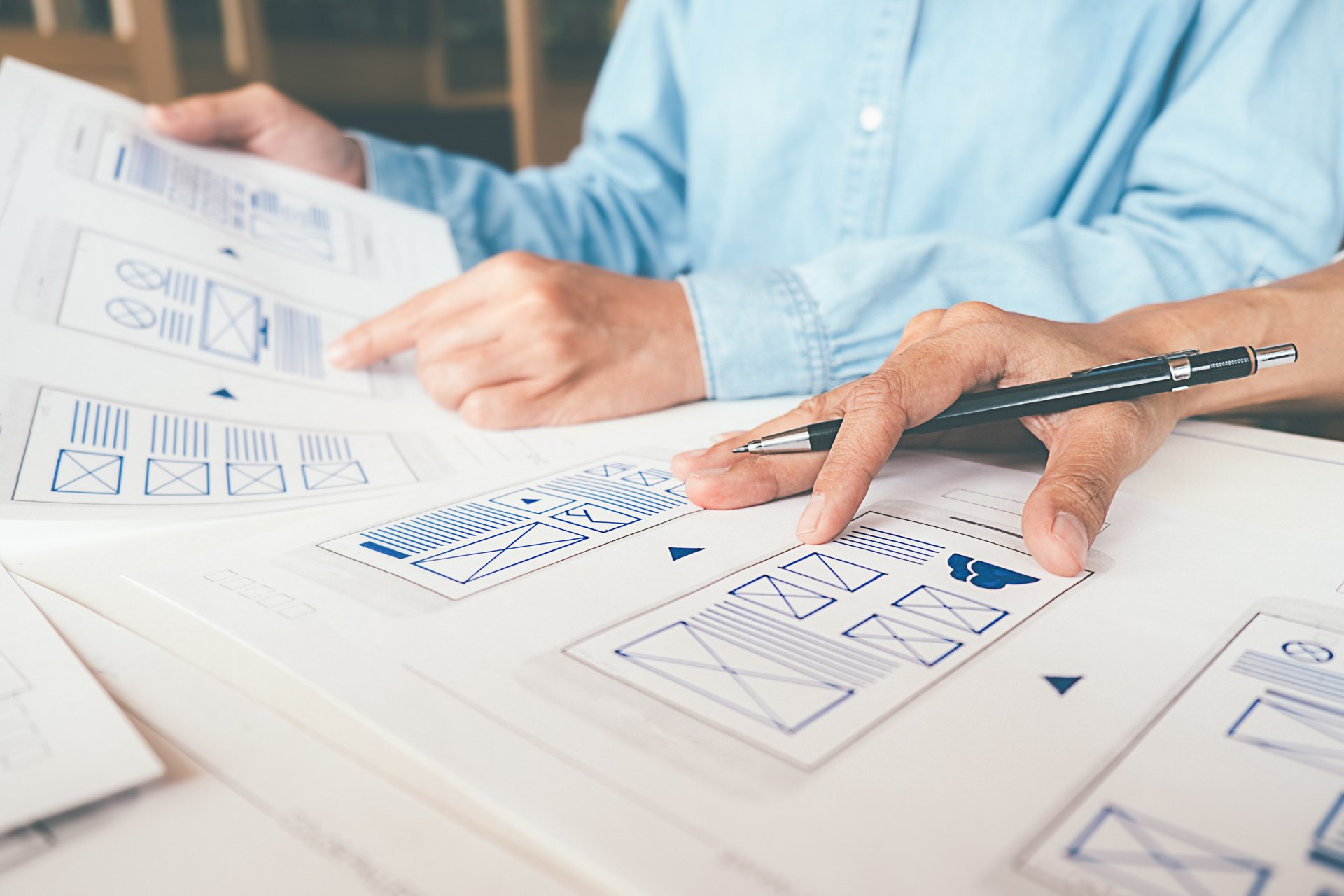 People reviewing interface sketches on paper