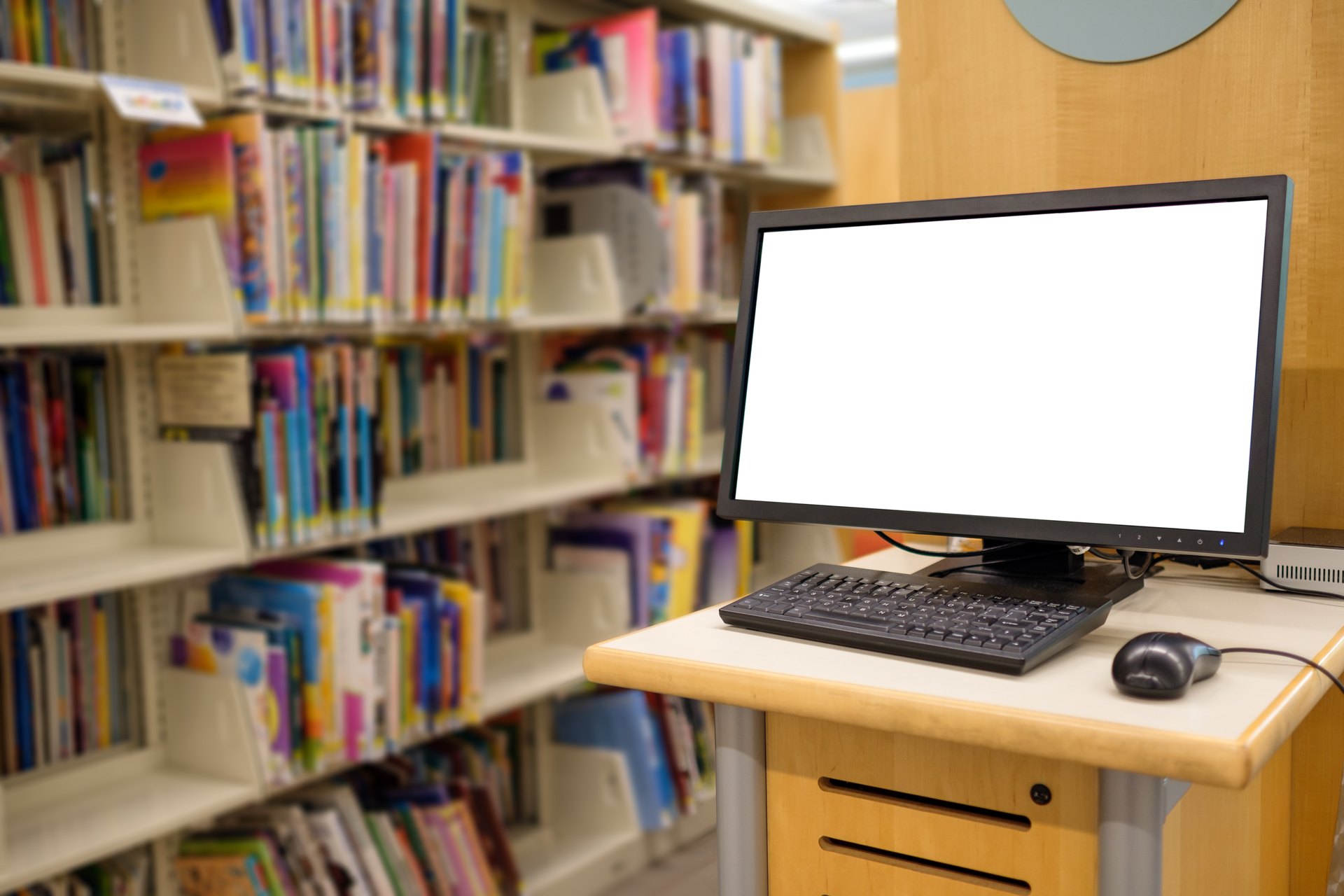 Computer workstation among library bookshelves