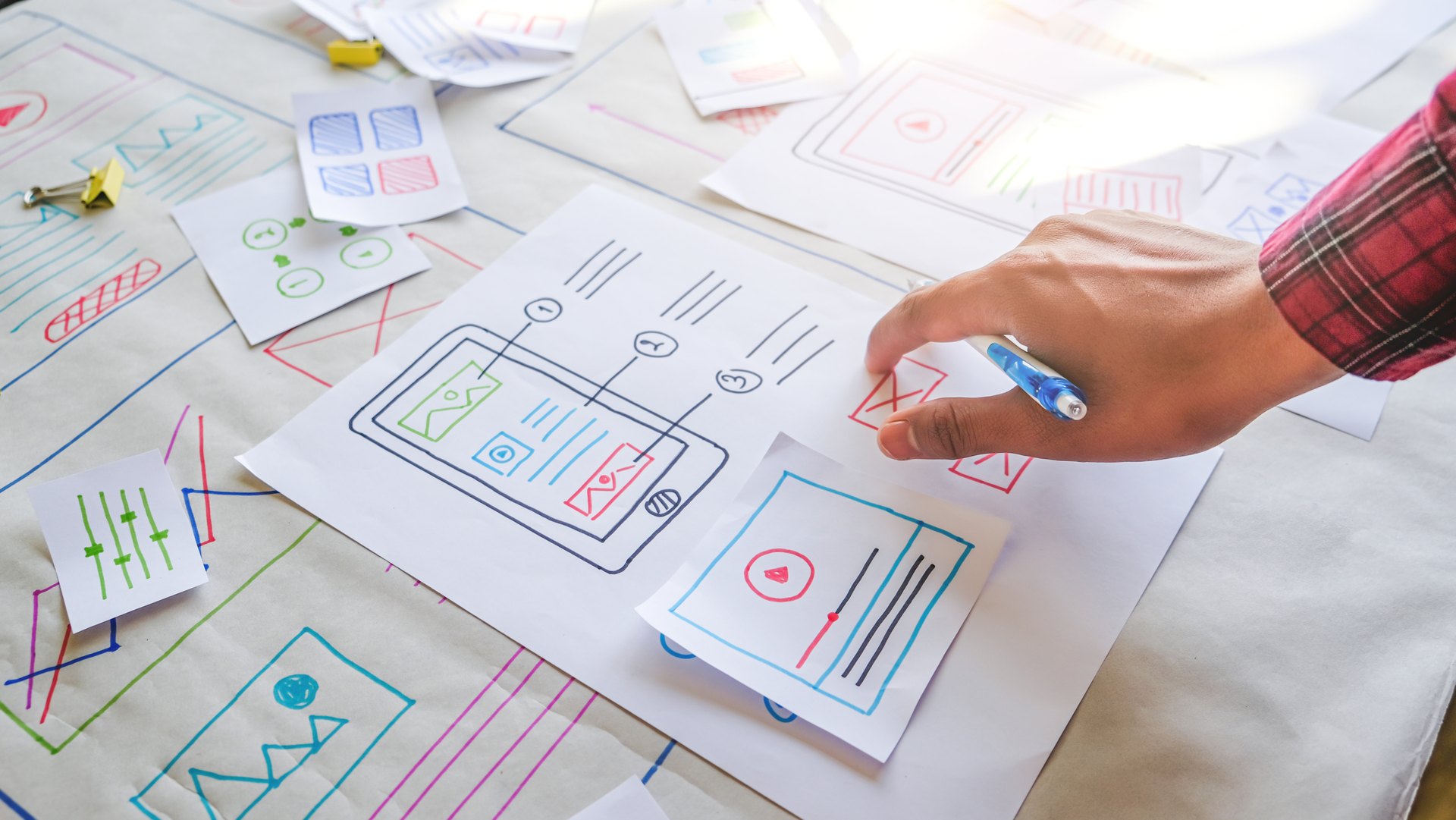 Person reviewing interface drawings on a desk
