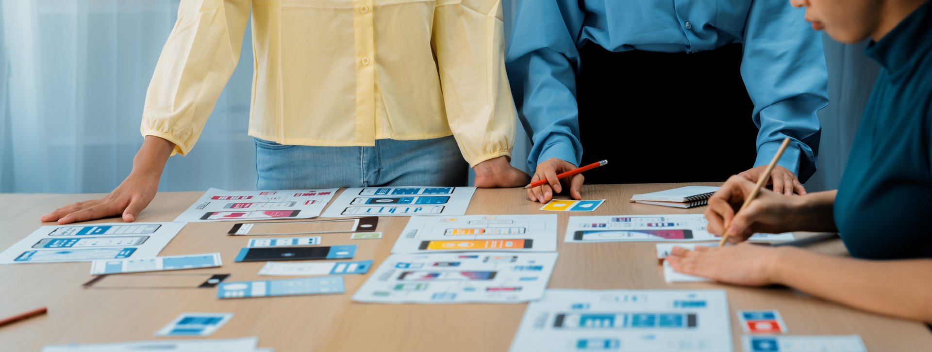 People collaborating around a table of design materials