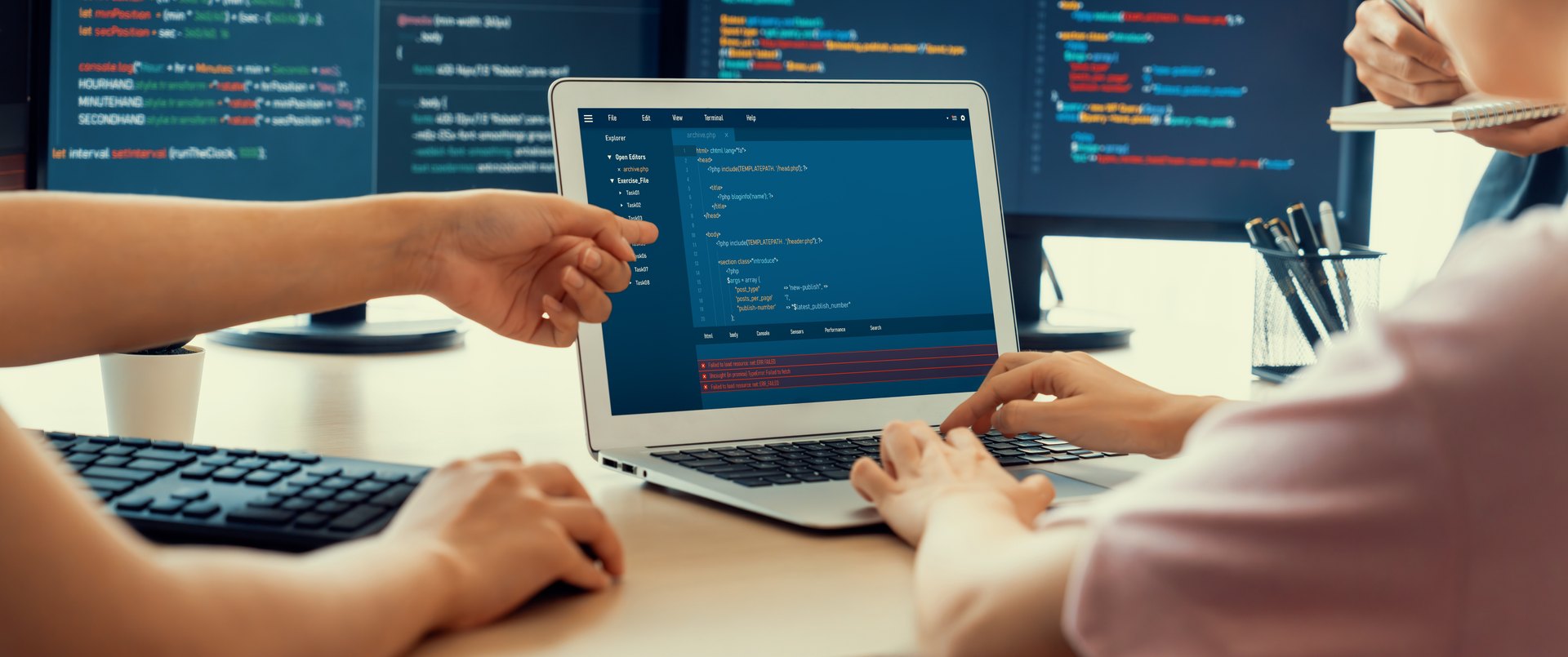 Two people discussing code on a laptop