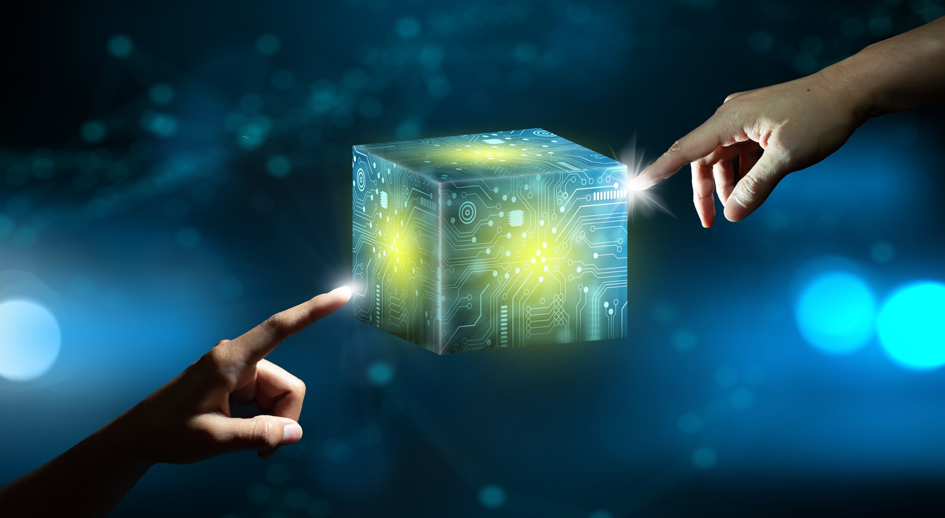 Hands pointing toward an abstract illuminated digital cube