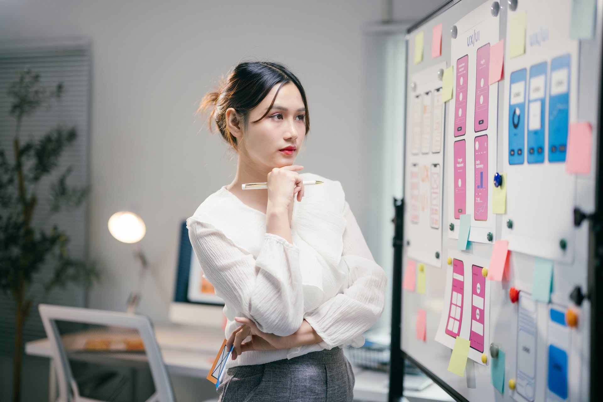 Designer considering a wall of planning notes